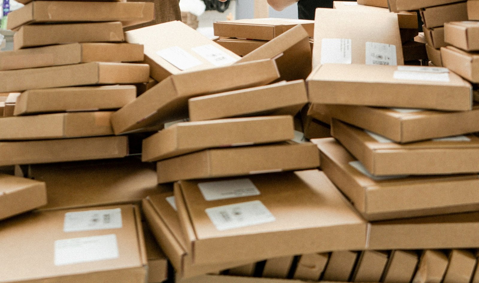Hands packing an item into a shipping box